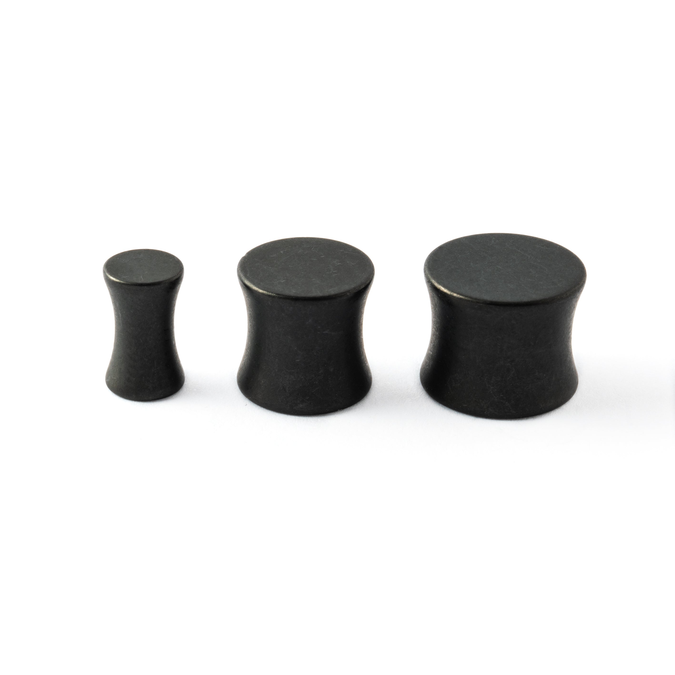 several sizes of surgical steel black steel plugs with double flared ends side view