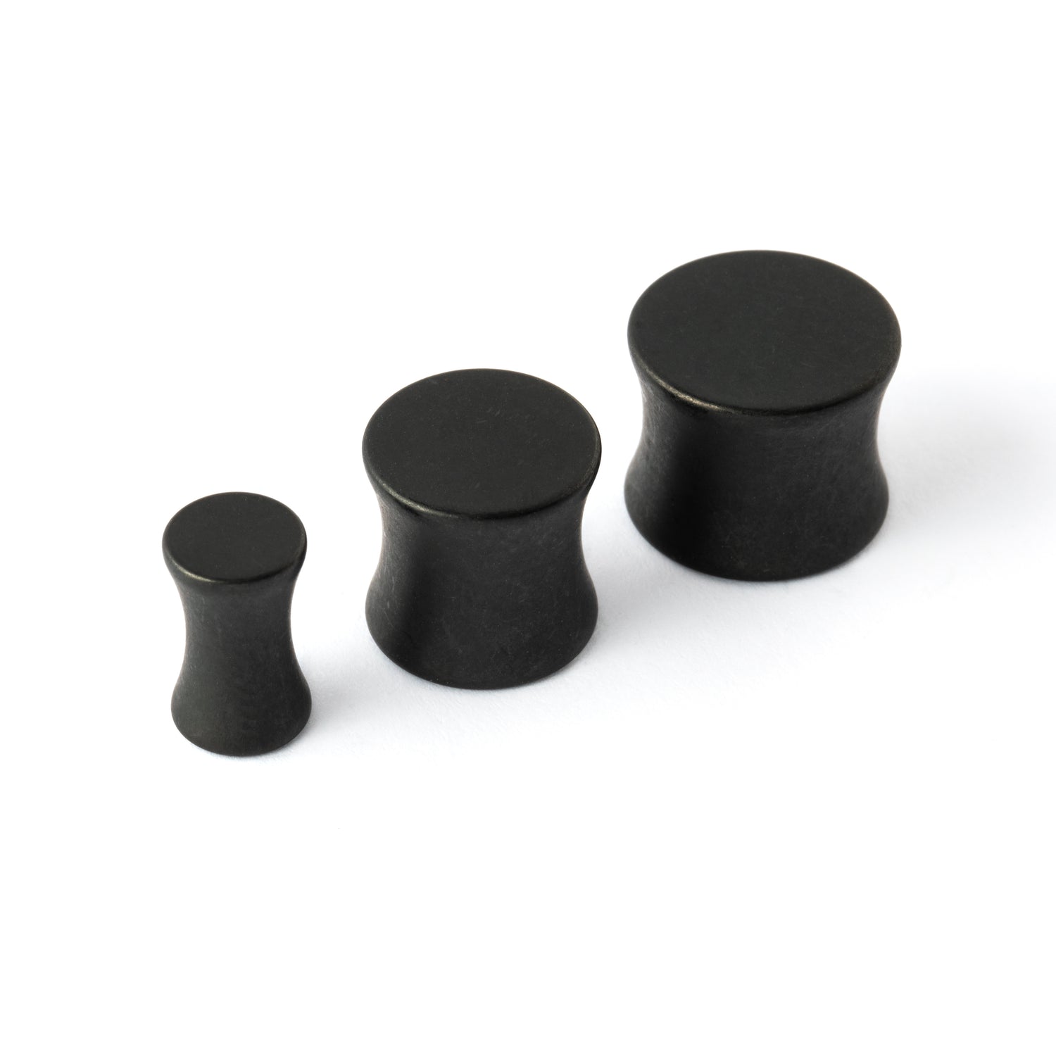 several sizes of surgical steel black steel plugs with double flared ends right front view