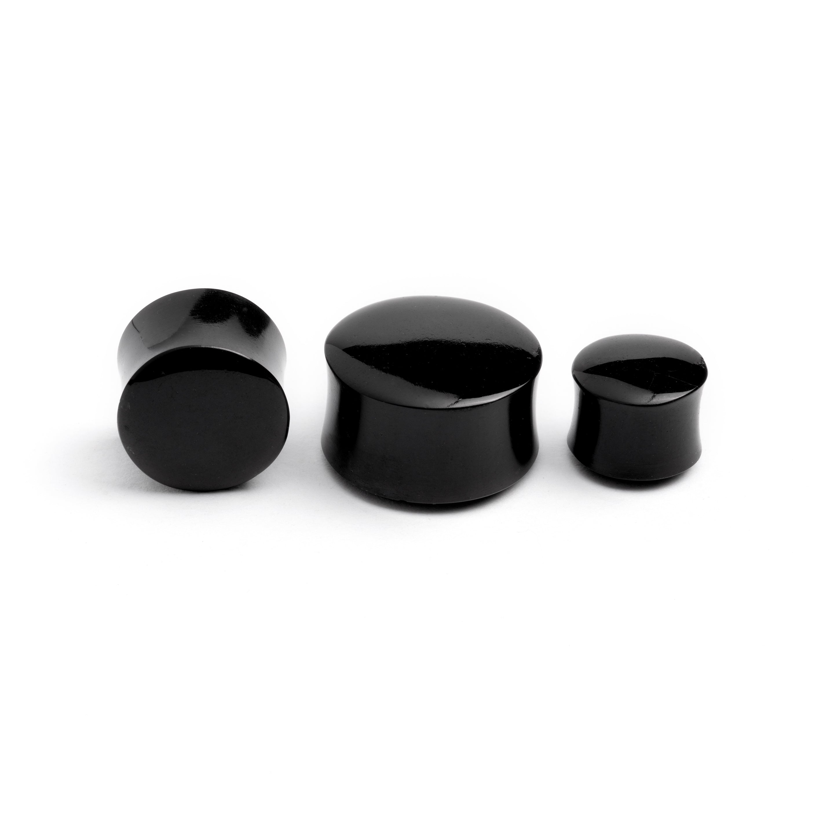 several sizes of black agate ear plugs frontal and side view