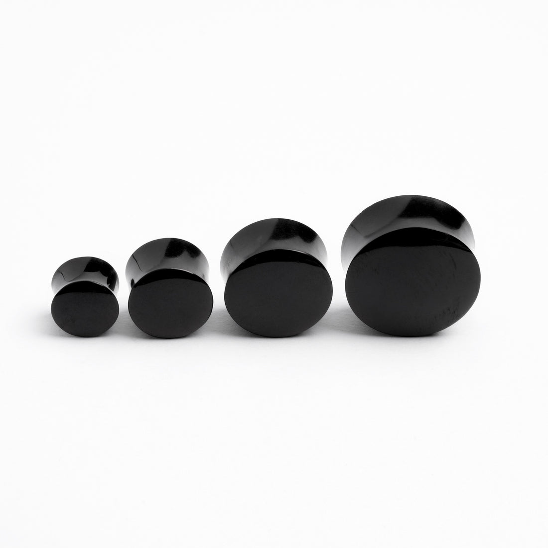 several sizes of black agate ear plugs frontal view