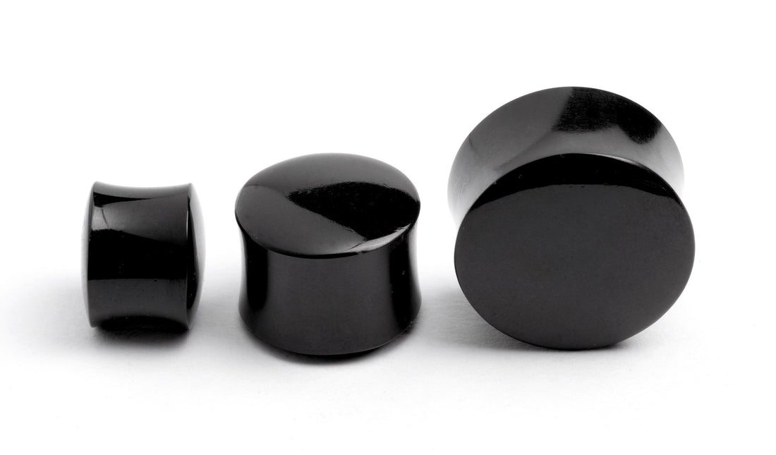 several sizes of black agate ear plugs 
