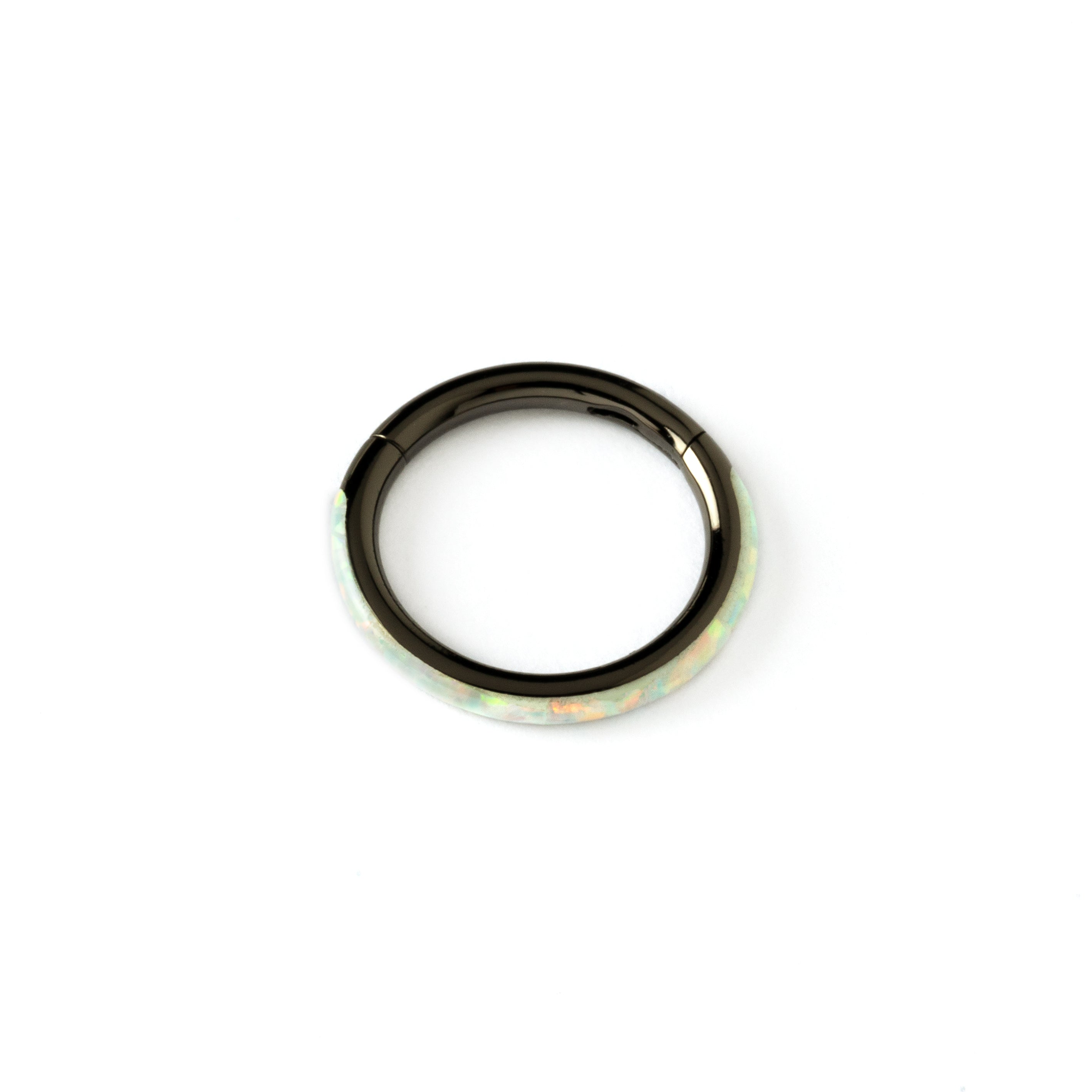 shiny black surgical steel clicker ring with white opal adorned its outer rim above view