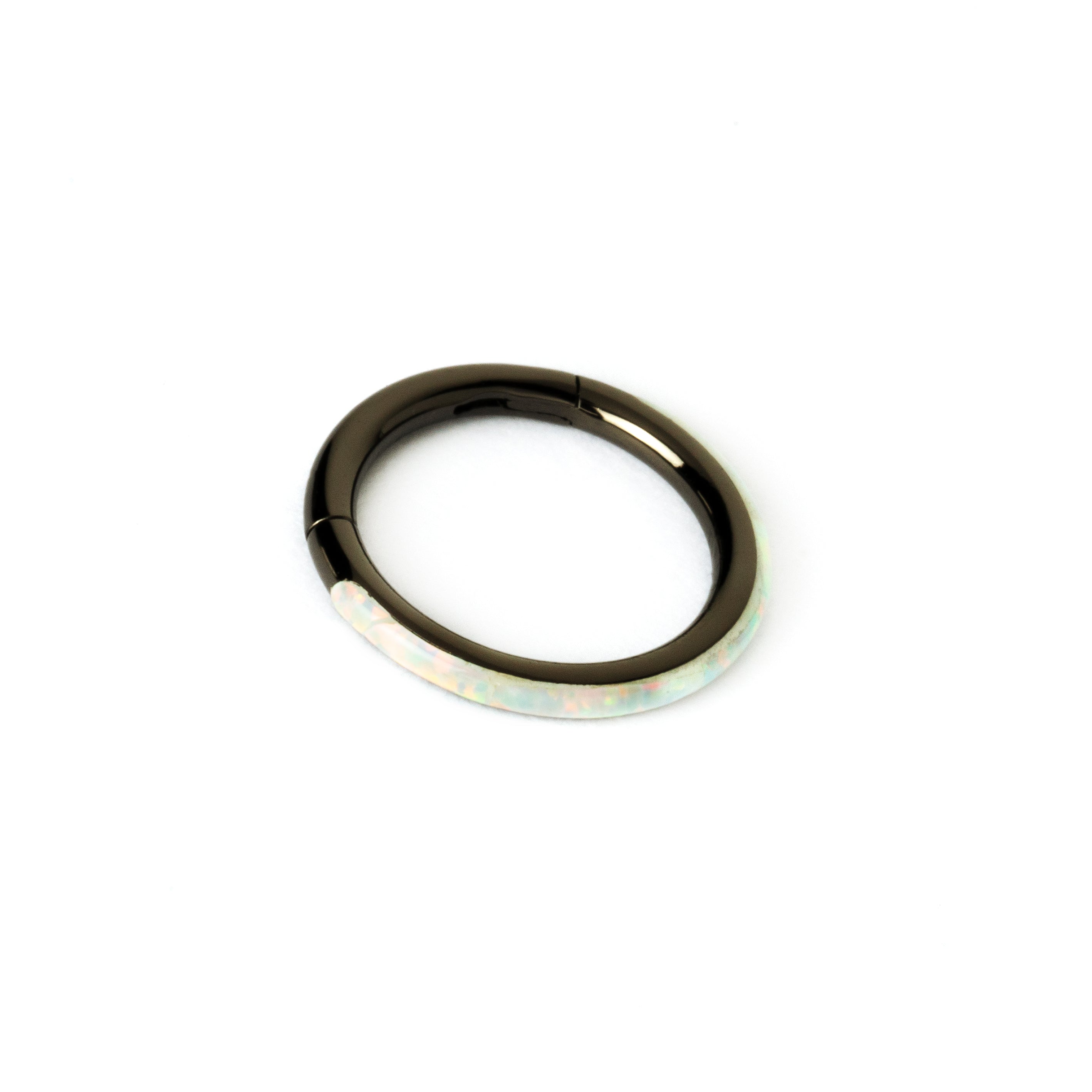 shiny black surgical steel clicker ring with white opal adorned its outer rim left side view