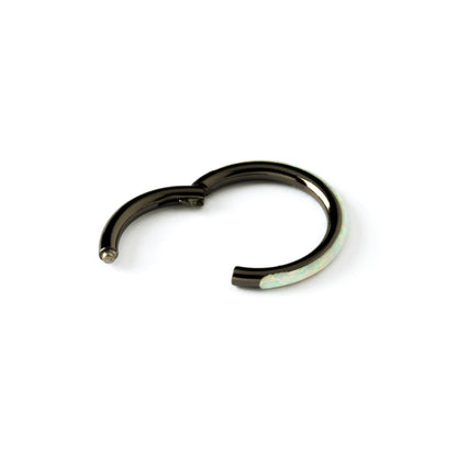 shiny black surgical steel clicker ring with white opal adorned its outer rim closure view