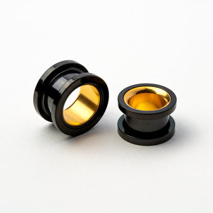 two black and gold surgical steel ear tunnels side and front right view