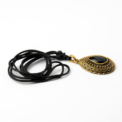 Teardrop shaped pendant with black Onyx stone encircled by Celtic ornaments. Black Onyx is a crystal to guide your spiritual journey by bringing the true reflection of your soul.   Material: Brass, Black Onyx Nickel, cadmium and lead free. Dimension: H 40mm , W 30mm Comes on an adjustable black cotton string.