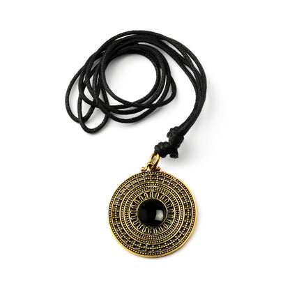 golden brass mandala pendant with centred black onyx stone on an adjustable cotton string frontal view