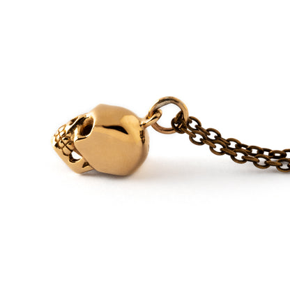 tiny bronze skull pendant on a bronze chain necklace side view