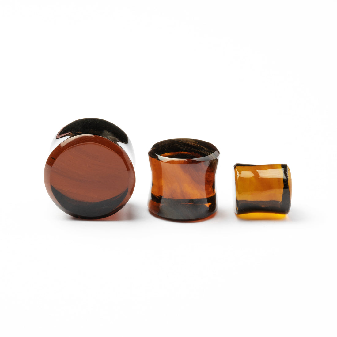 several sizes of Brown Volcanic Glass double flare ear plugs side and front view