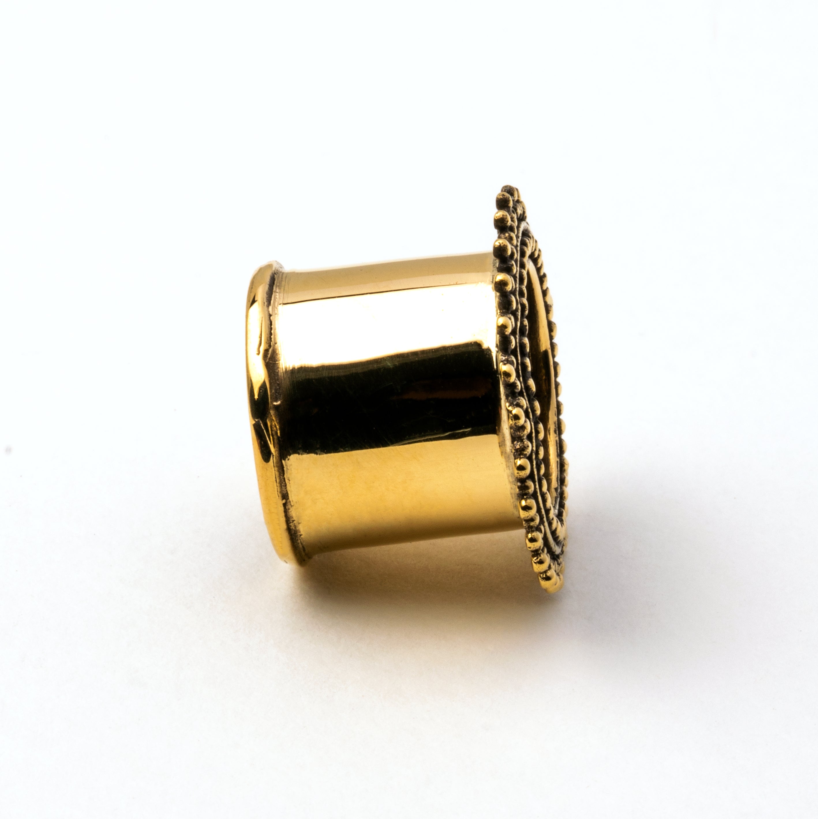 single golden brass Indian ear tunnel side view