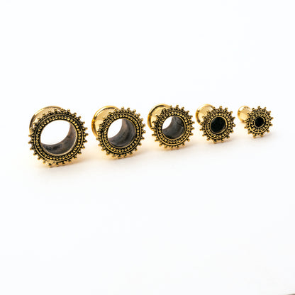 several sizes of golden brass Indian ear tunnel front side view