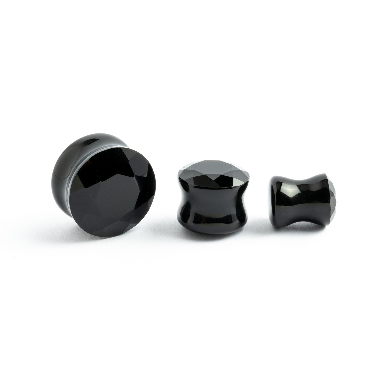 several sizes of faceted black onyx ear plugs
