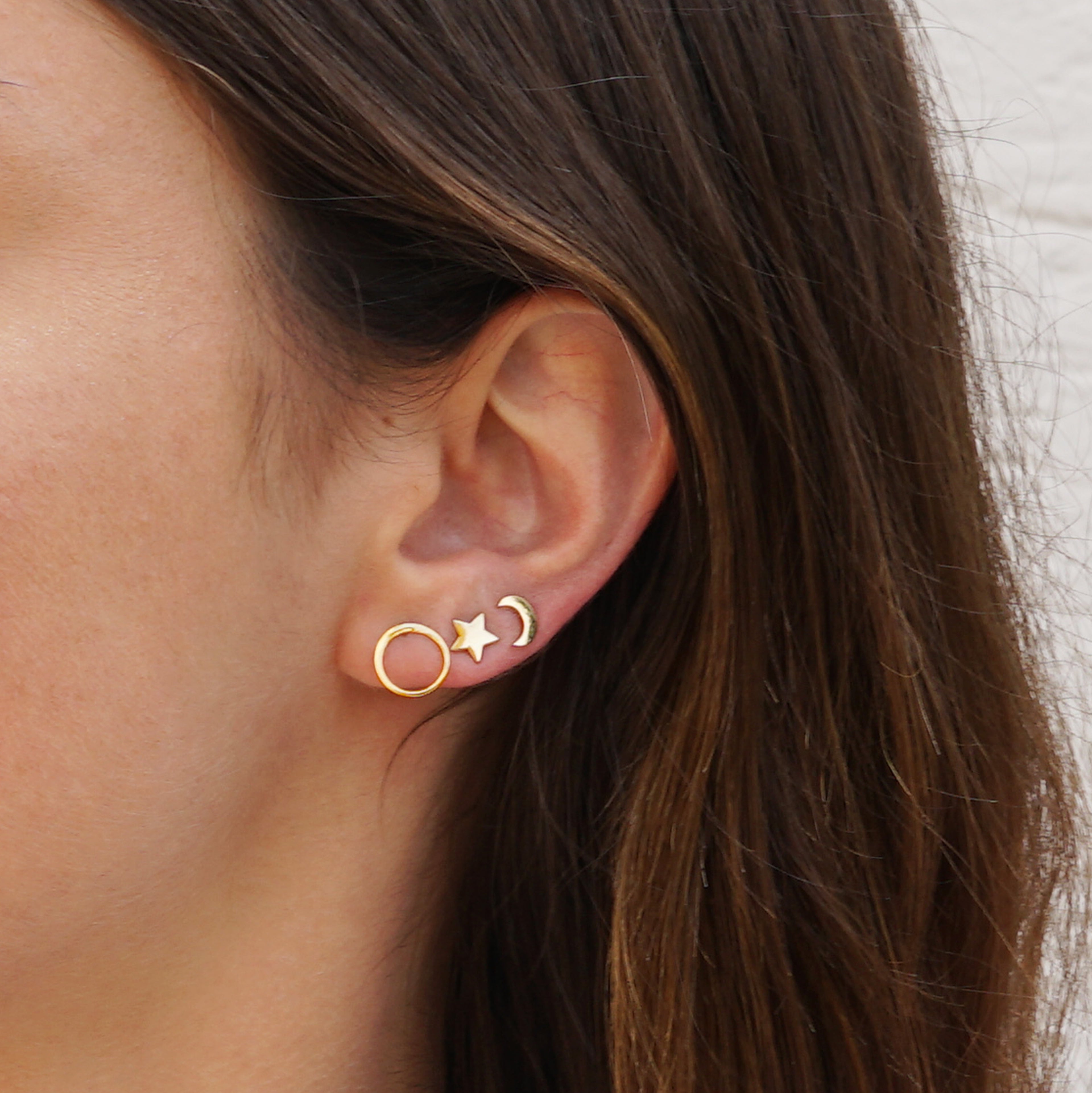 model wearing Gold circle ear studs and moon and star studs
