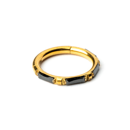 Gold septum clicker with black onyx stones around its rim right side view