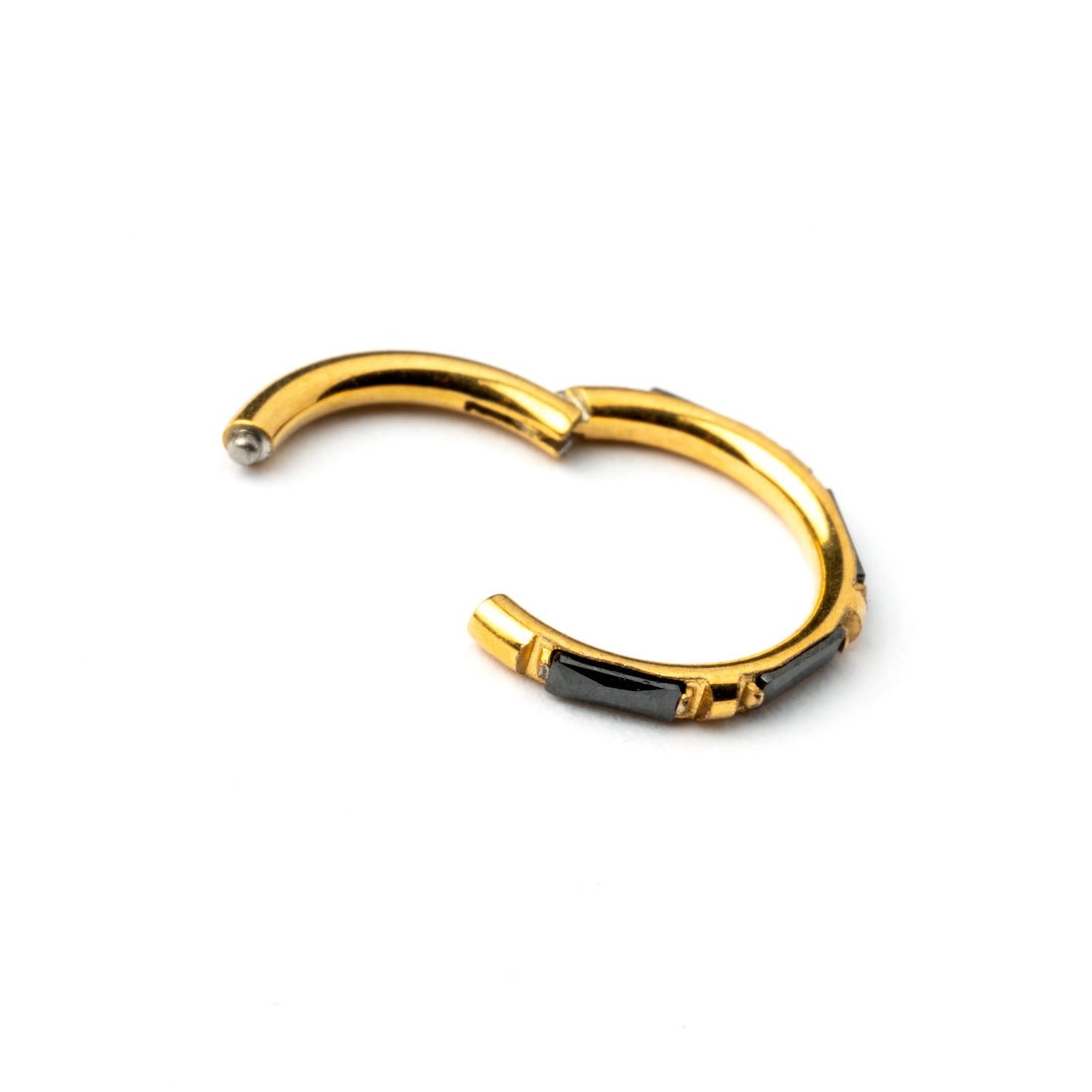 Gold septum clicker with black onyx stones around its rim closure view