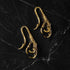 pair of gold brass dragon claw ear hangers left side view on a black background