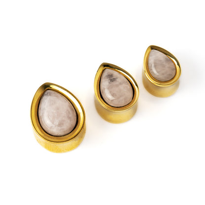 several sizes of Golden brass teardrop rose quartz ear plugs front side view