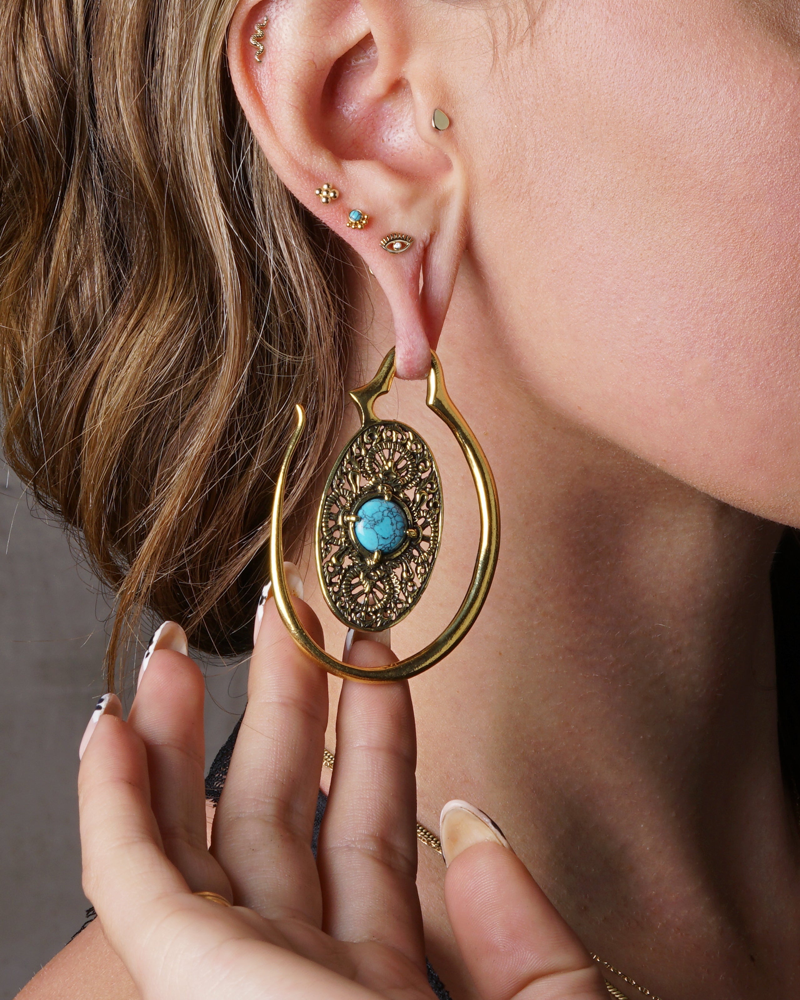 model wearing 14k Gold internally threaded screw back earring 1.2mm (16g), 8mm, dots flower labret stud on her upper lobe