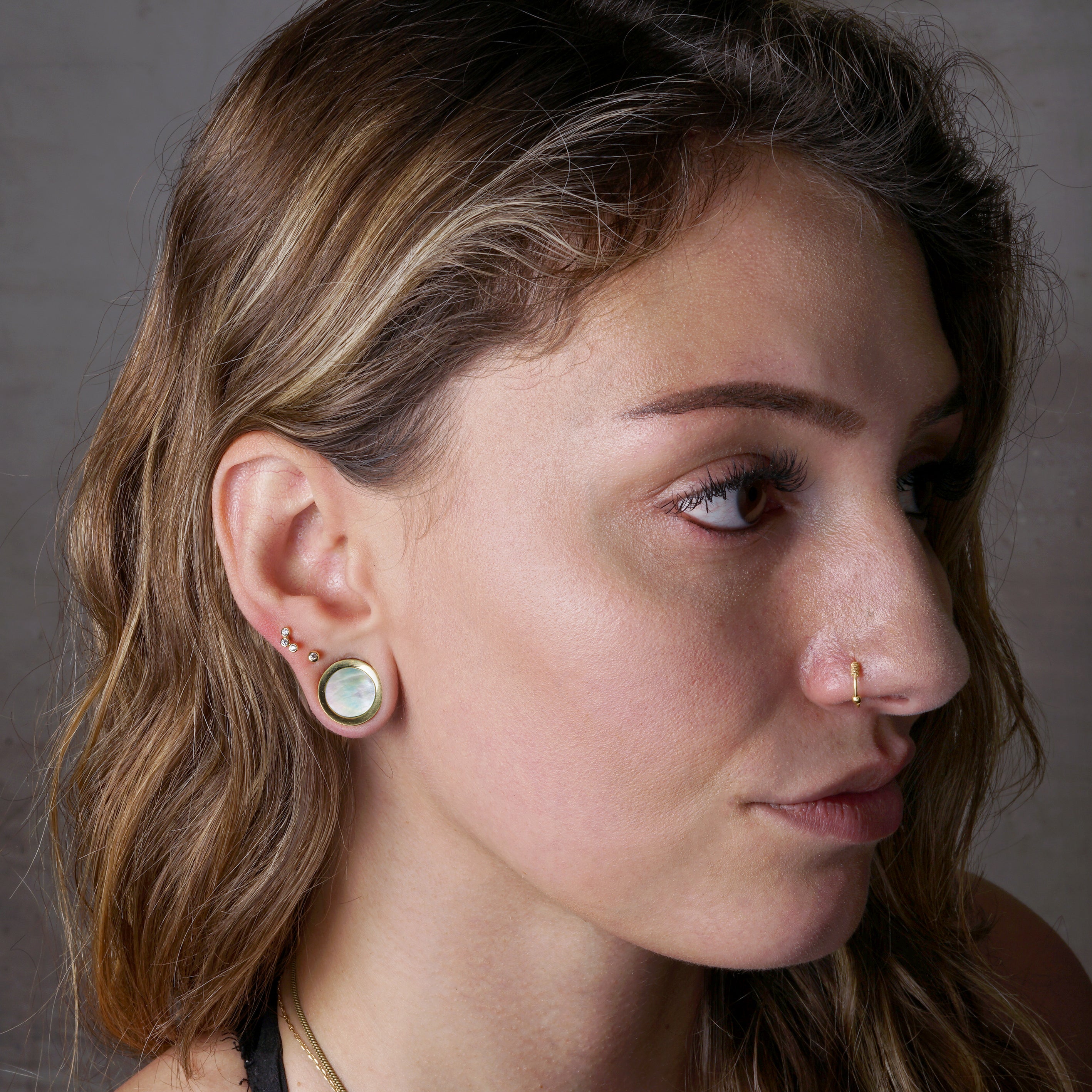 model wearing Golden Plugs with a Mother of Pearl