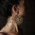 model wearing golden brass large lotus open mandala earrings with centred abalone