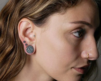 model wearing hammered black silver double flared ear plug 