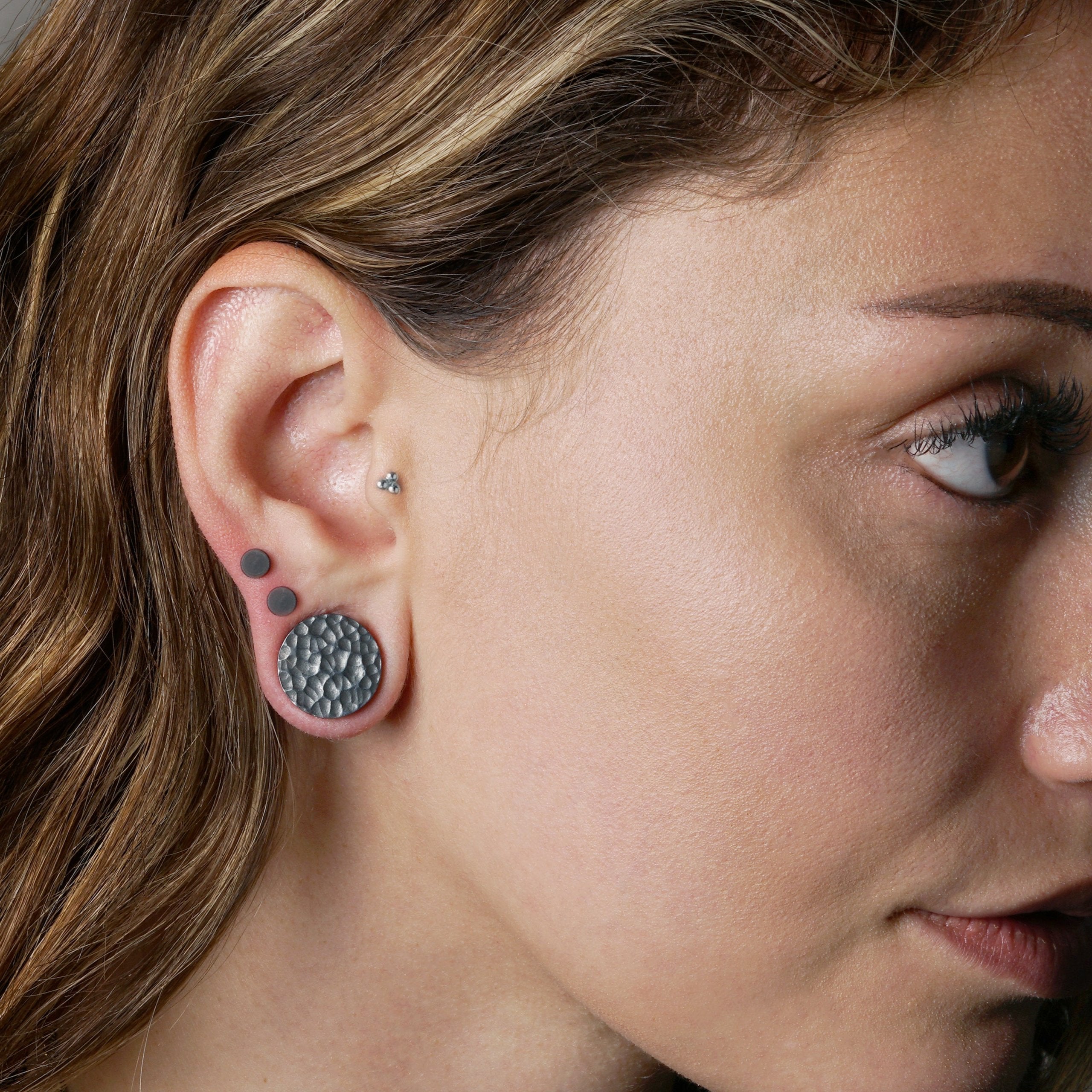 model wearing hammered black silver double flared ear plug 
