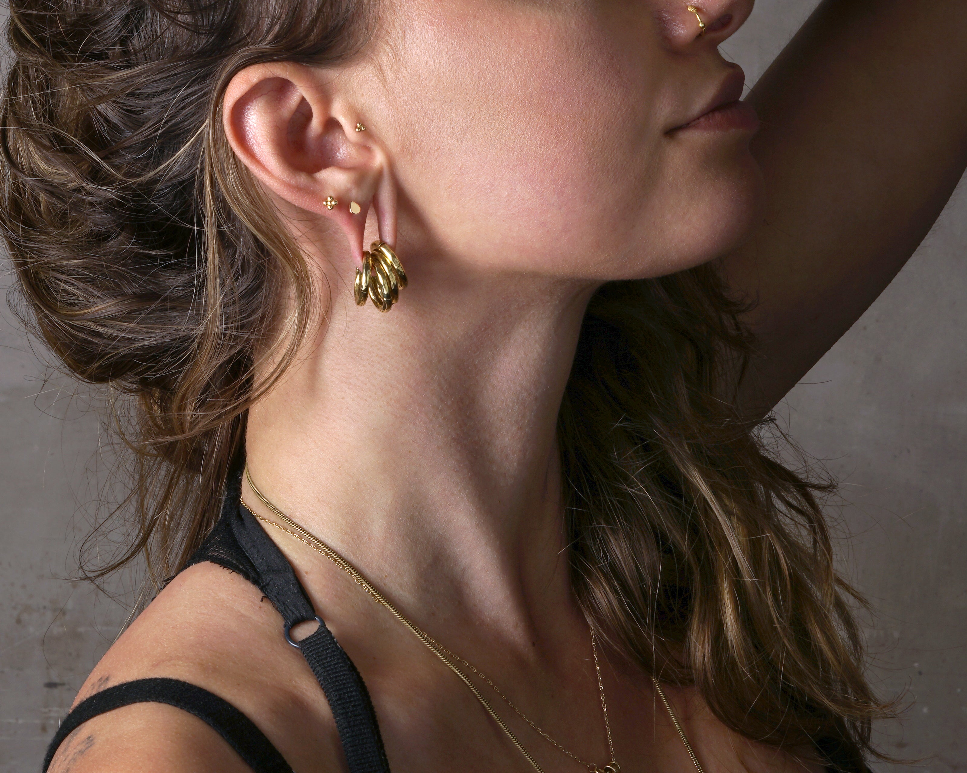 model wearing 14k Gold internally threaded screw back earring 1.2mm (16g), 8mm, dots flower labret stud
