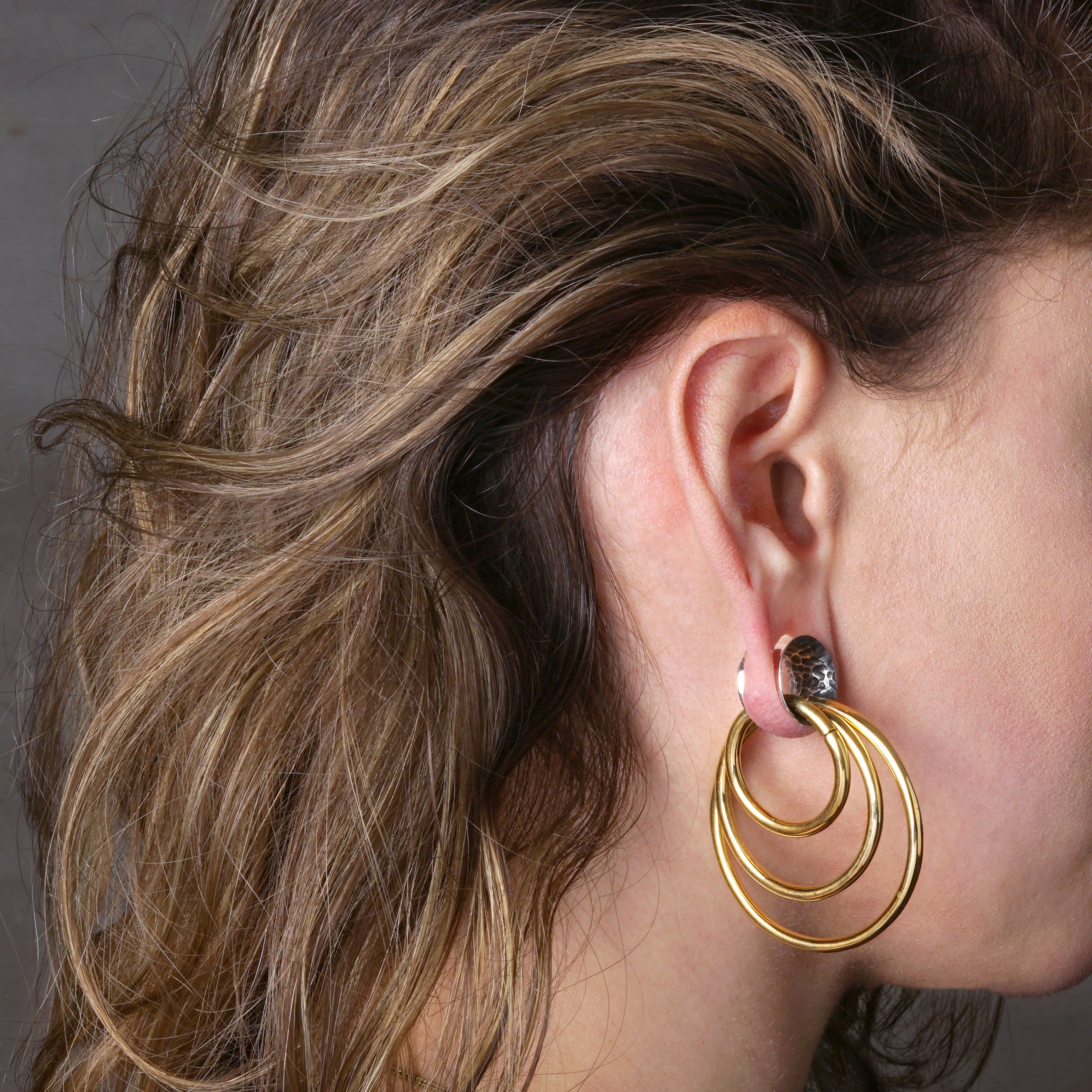 model wearing stacking hoop hangers with hammered silver tunnel