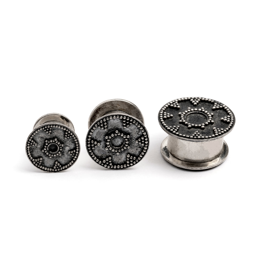 different sizes of tribal screw on silver plug tunnel ornamented with spheres frontal view