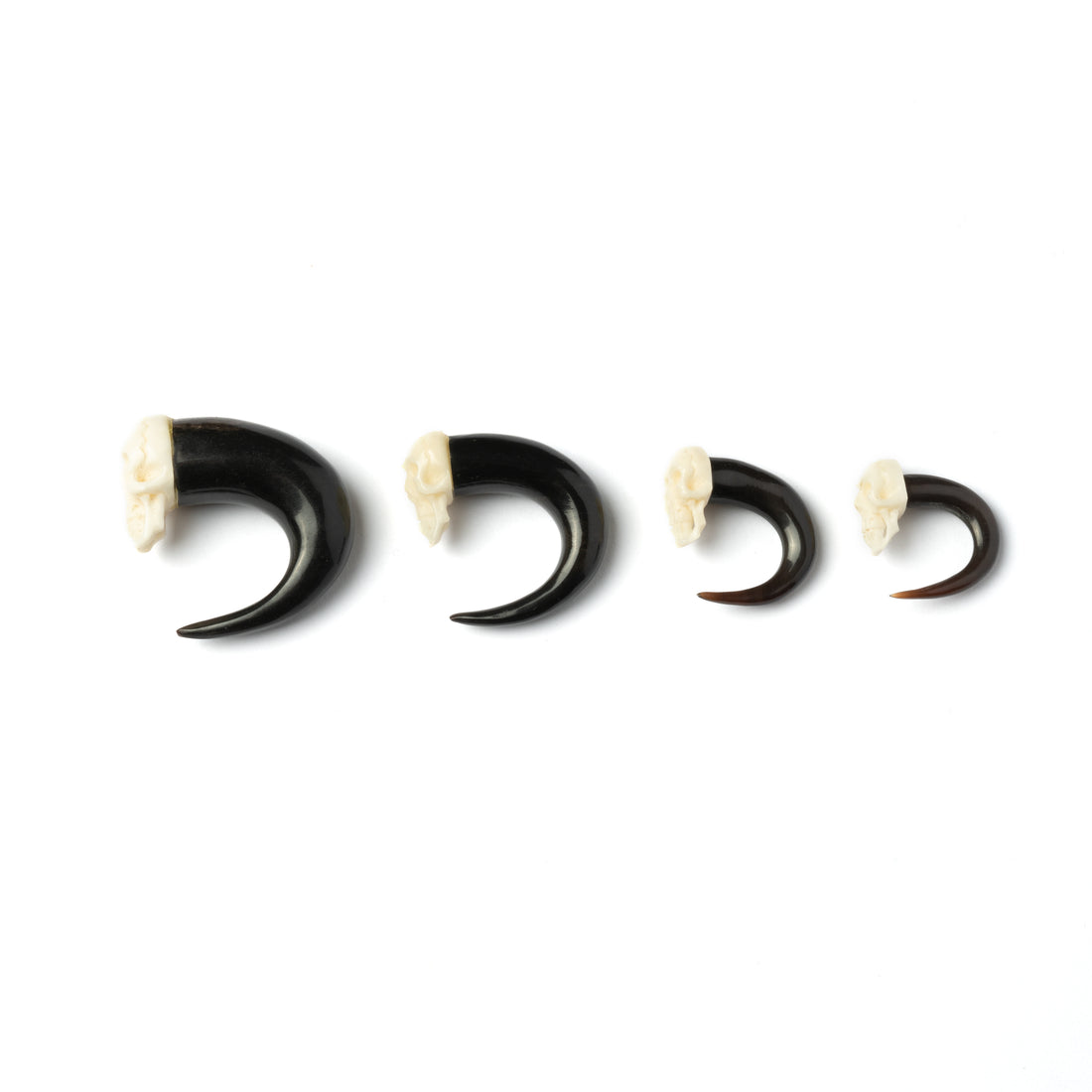several sizes of skull hook ear stretchers side view