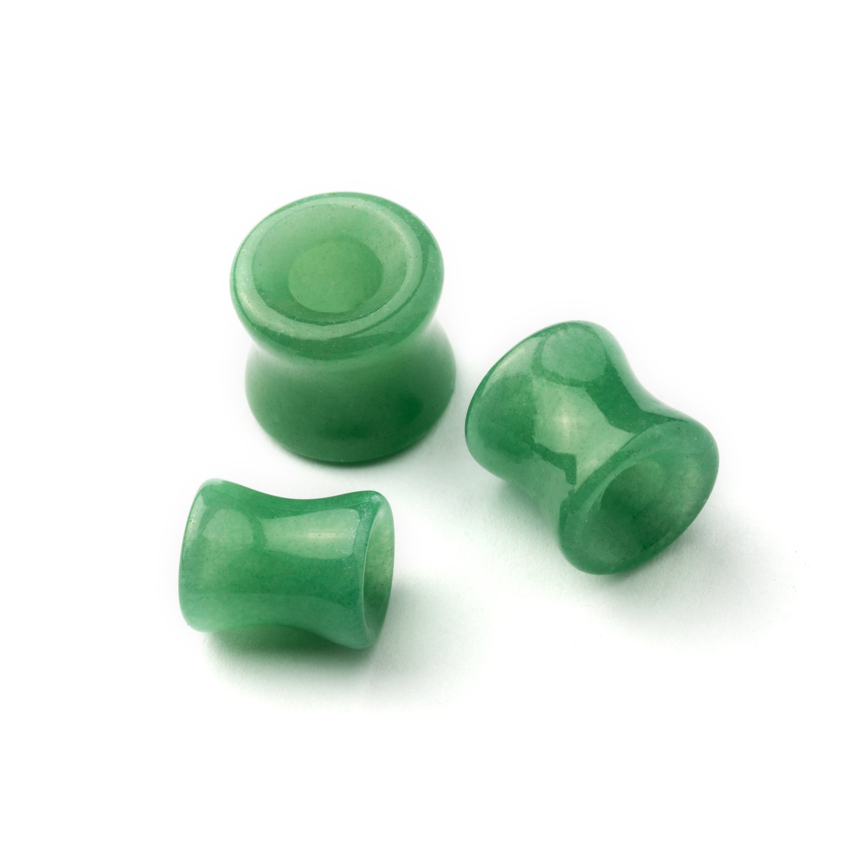 several sizes of green jade double flare stone ear tunnels front and side view