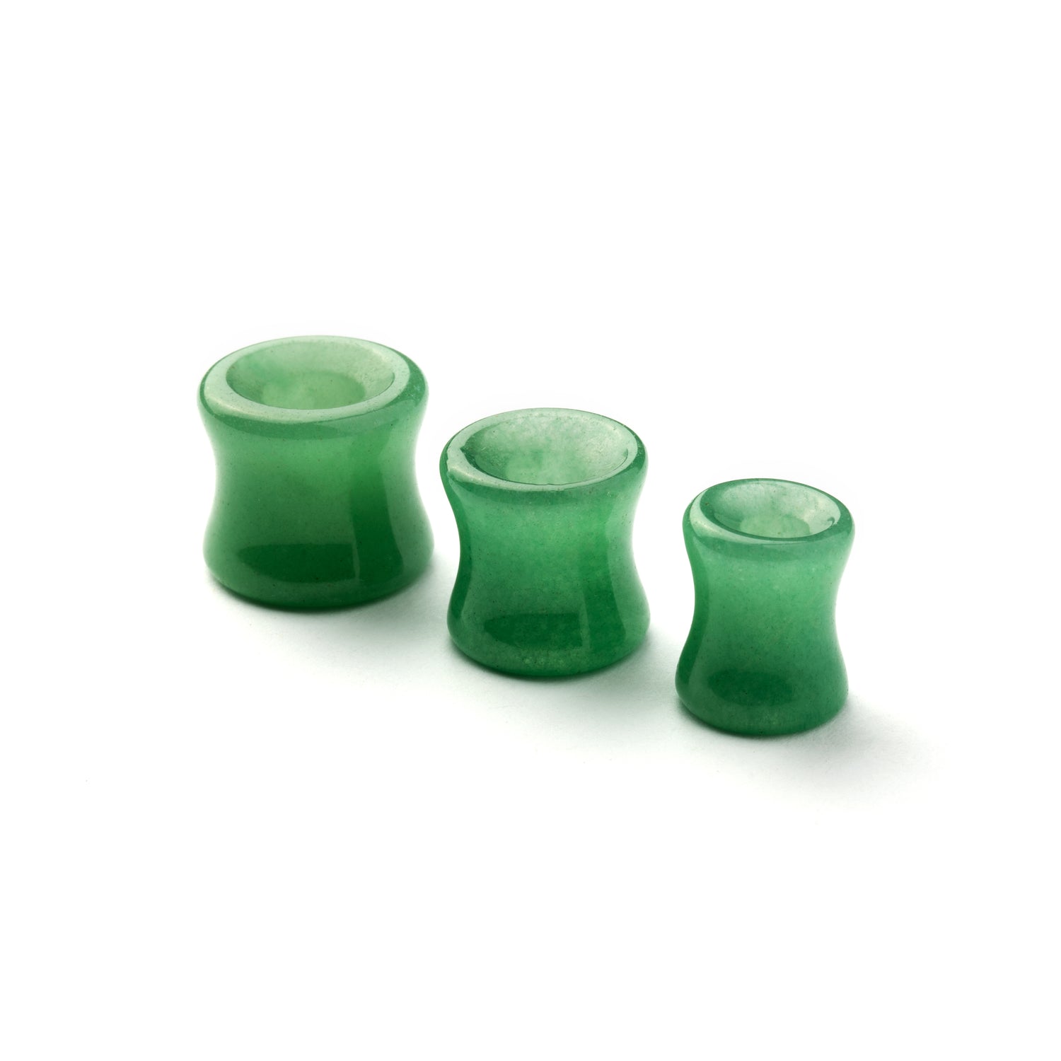 several sizes of green jade double flare stone ear tunnels front side view