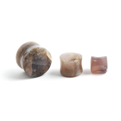 several sizes of lavender double flare stone ear plugs front and side view
