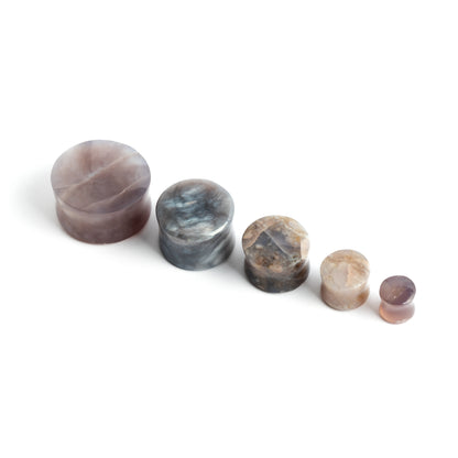 several sizes of lavender double flare stone ear plugs front view