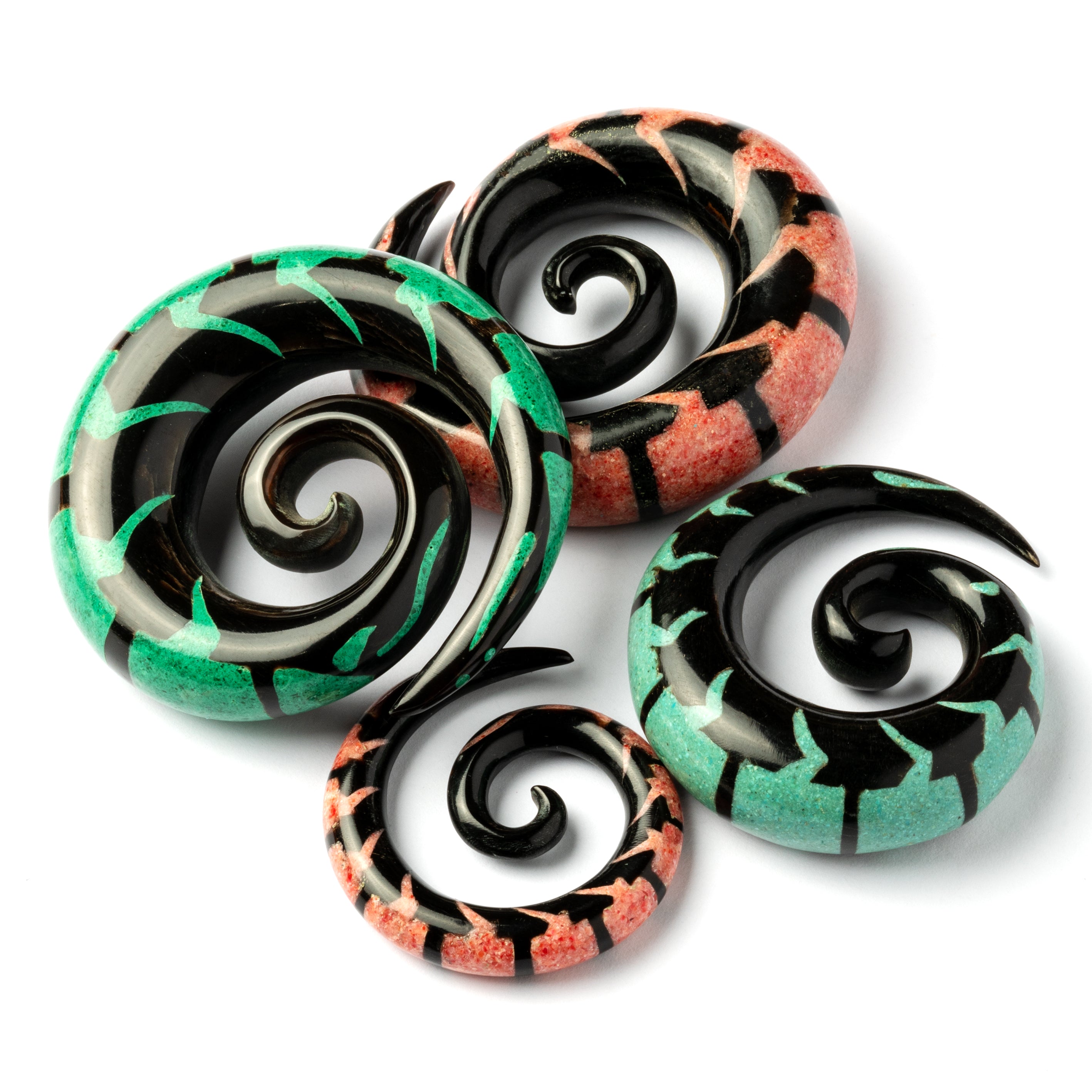 several sizes of spiral horn ear stretchers with centipede shaped red coral and Malachite inlay side view