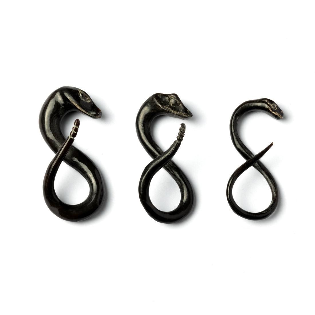 several sizes of horn snake ear stretchers in infinity shape side view