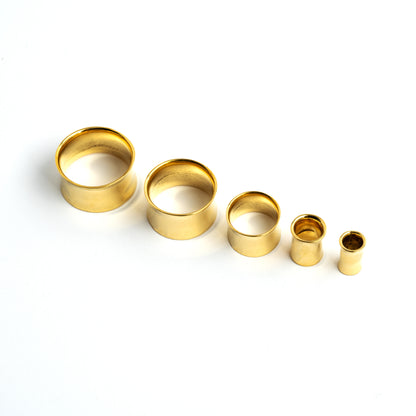 different sizes of minimalistic plain brass ear tunnels frontal view
