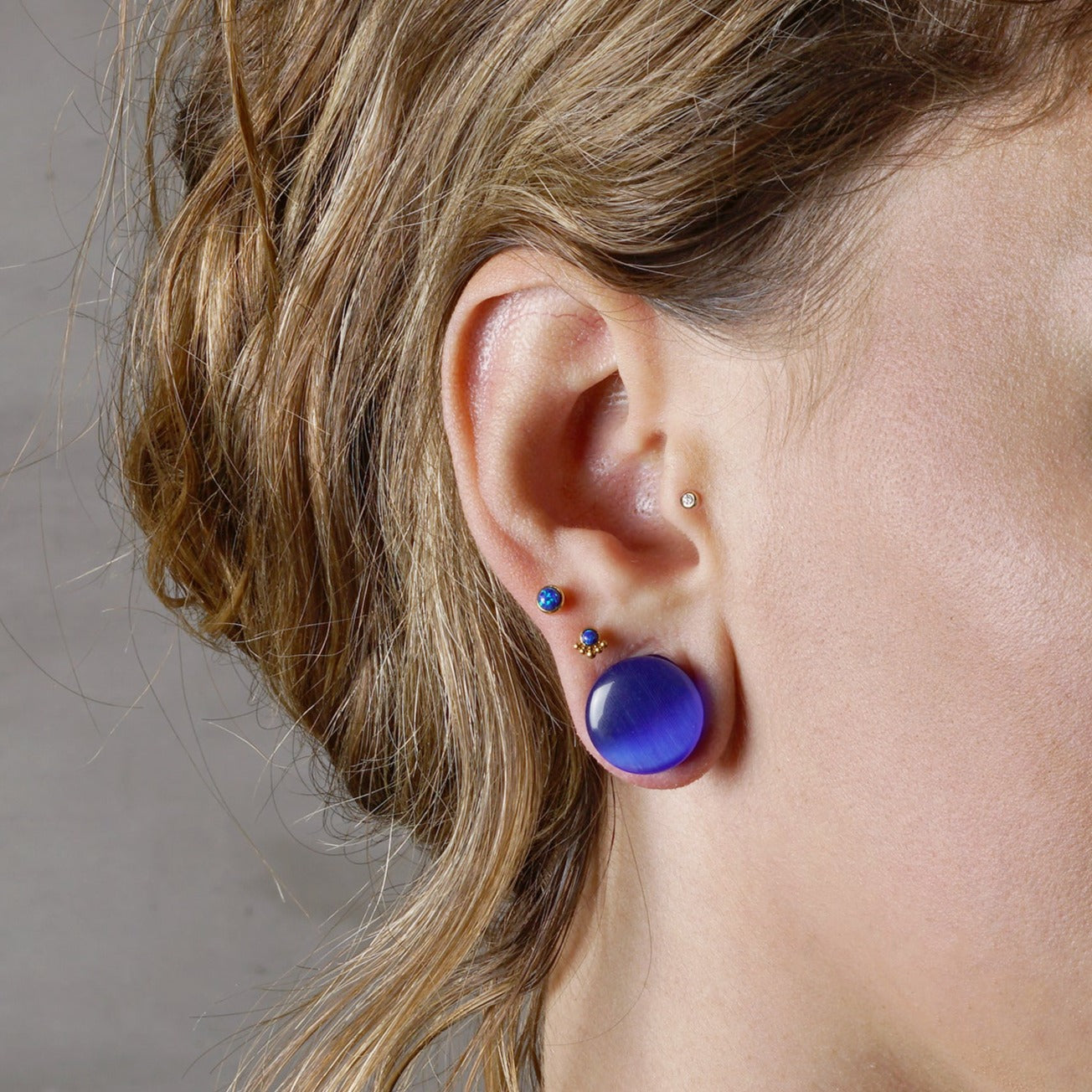 model wearing Blue cats eye stone plug with double flared ends