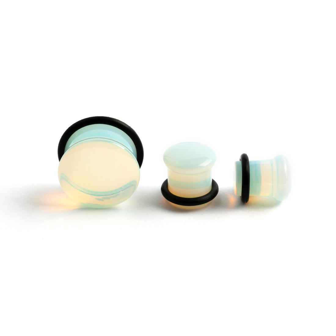 several sizes of Single flare Opalite stone ear plugs front and side view