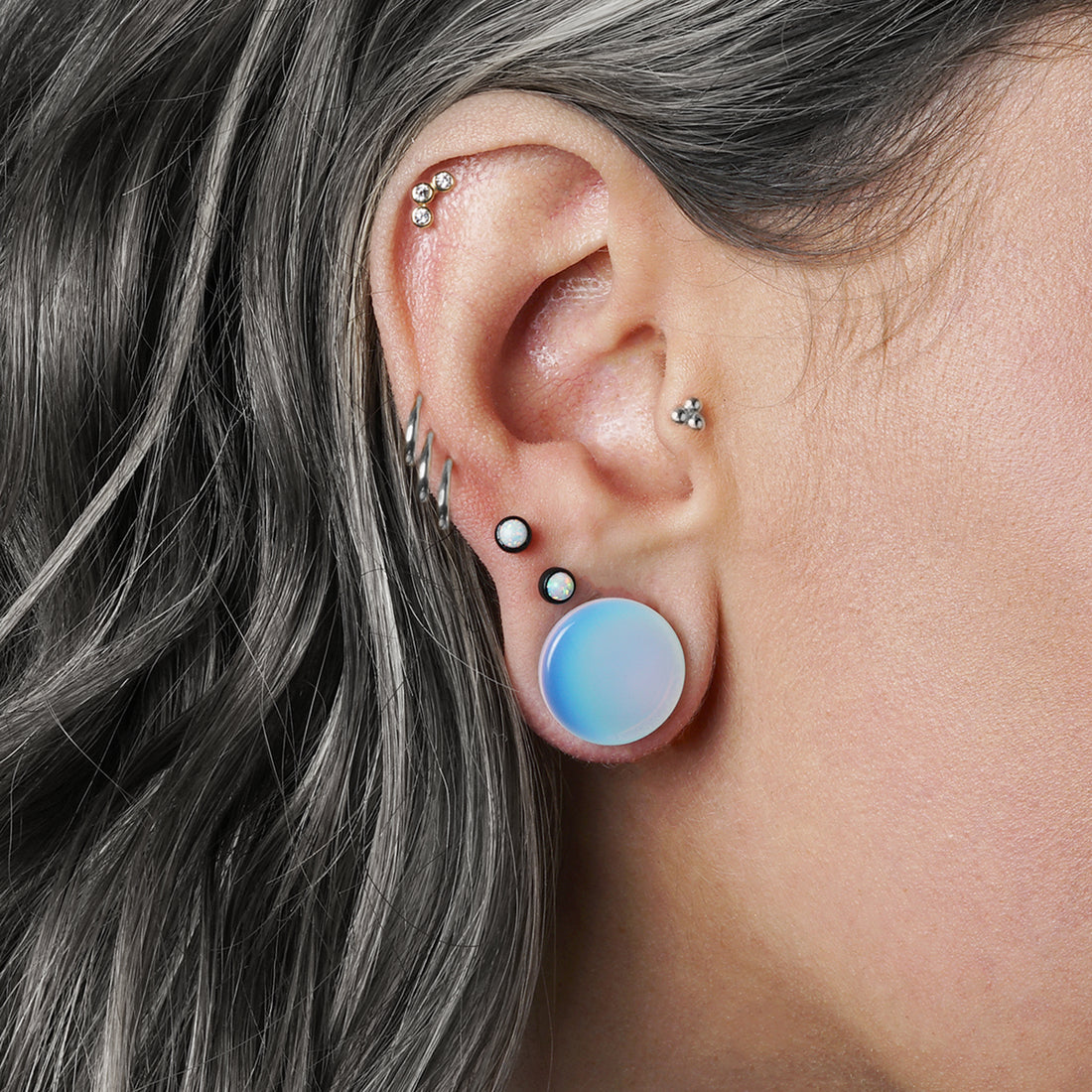 model wearing Opalite stone plug with double flared ends