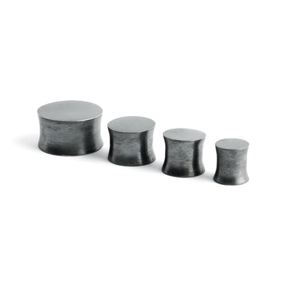several sizes of double flared black silver ear plugs front and side view