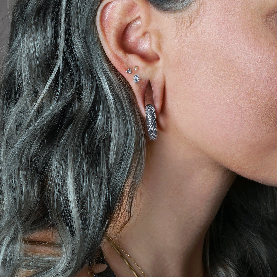 model wearing 14k white gold skull labret on her upper lobe