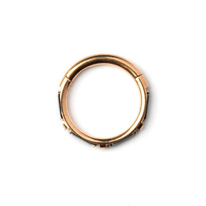 Rose Gold septum clicker with black onyx stones around its rim side view
