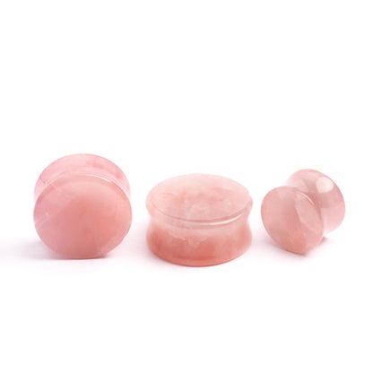 several sizes of rose quartz double flare stone ear plugs front and side view