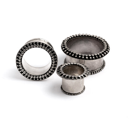 several sizes of silver orbit ear tunnels side and front view