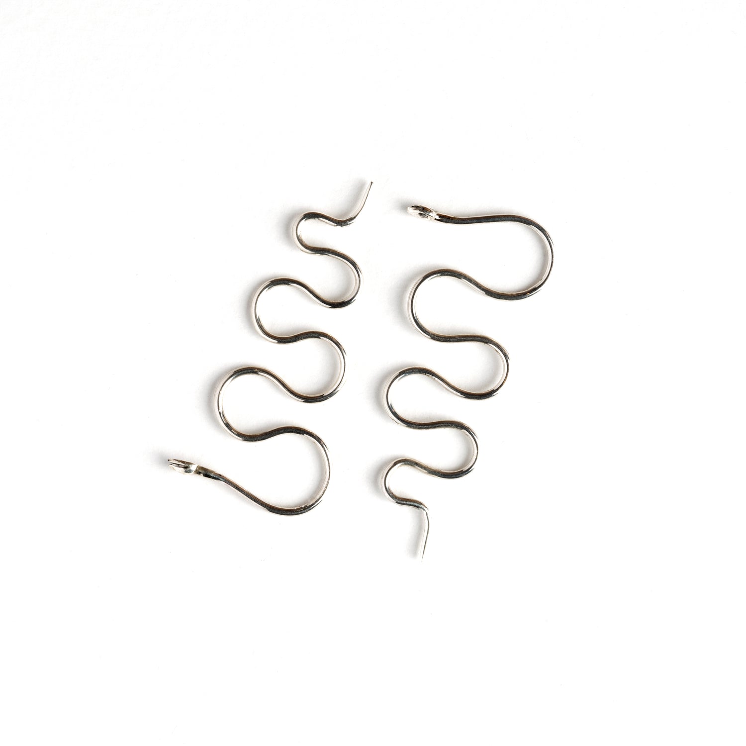 pair of silver wire snake hook earrings side view