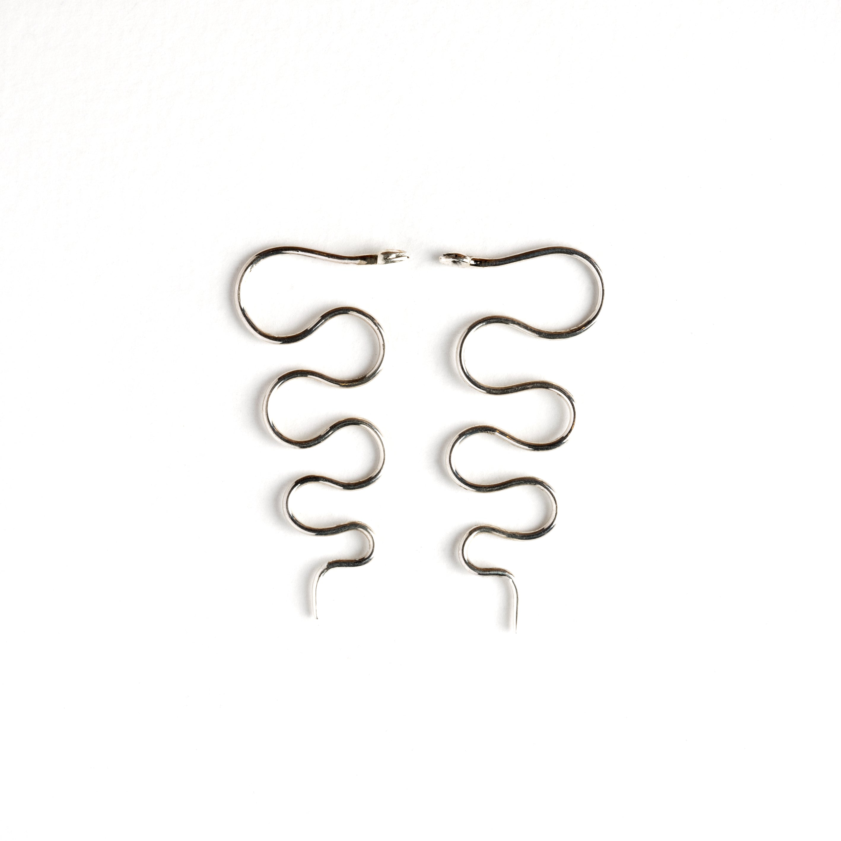 pair of silver wire snake hook earrings both sides view