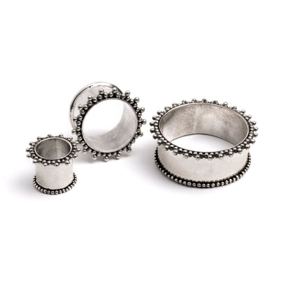 several sizes of double flared silver ear tunnels with tiny spheres front and side view