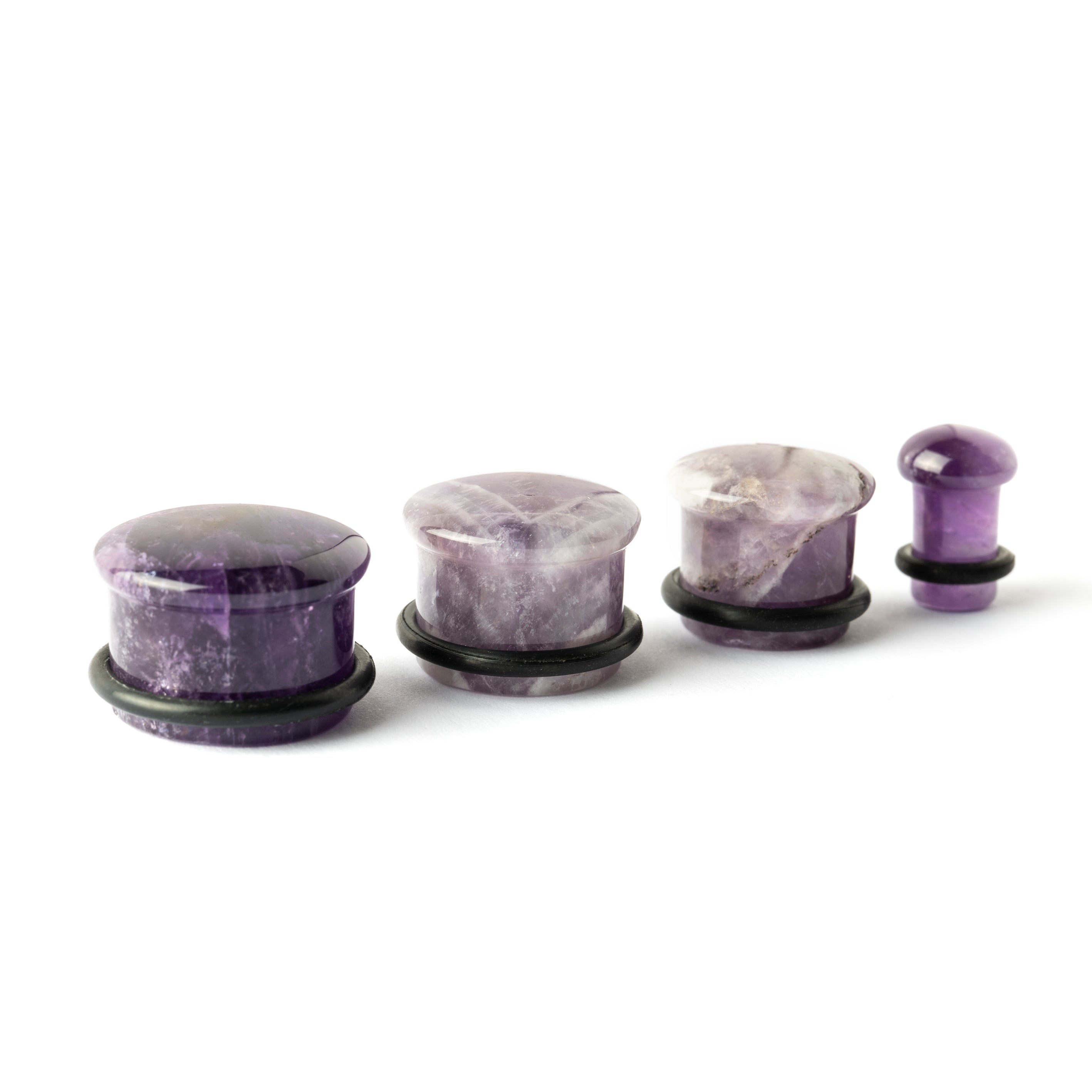 several sizes of Single Flare Amethyst stone ear plugs side view