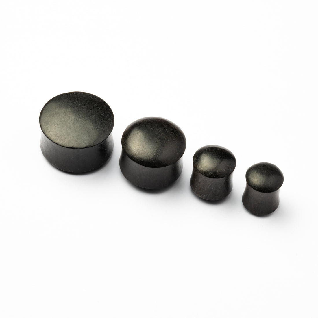 Several sizes of smooth black wood plugs front side view